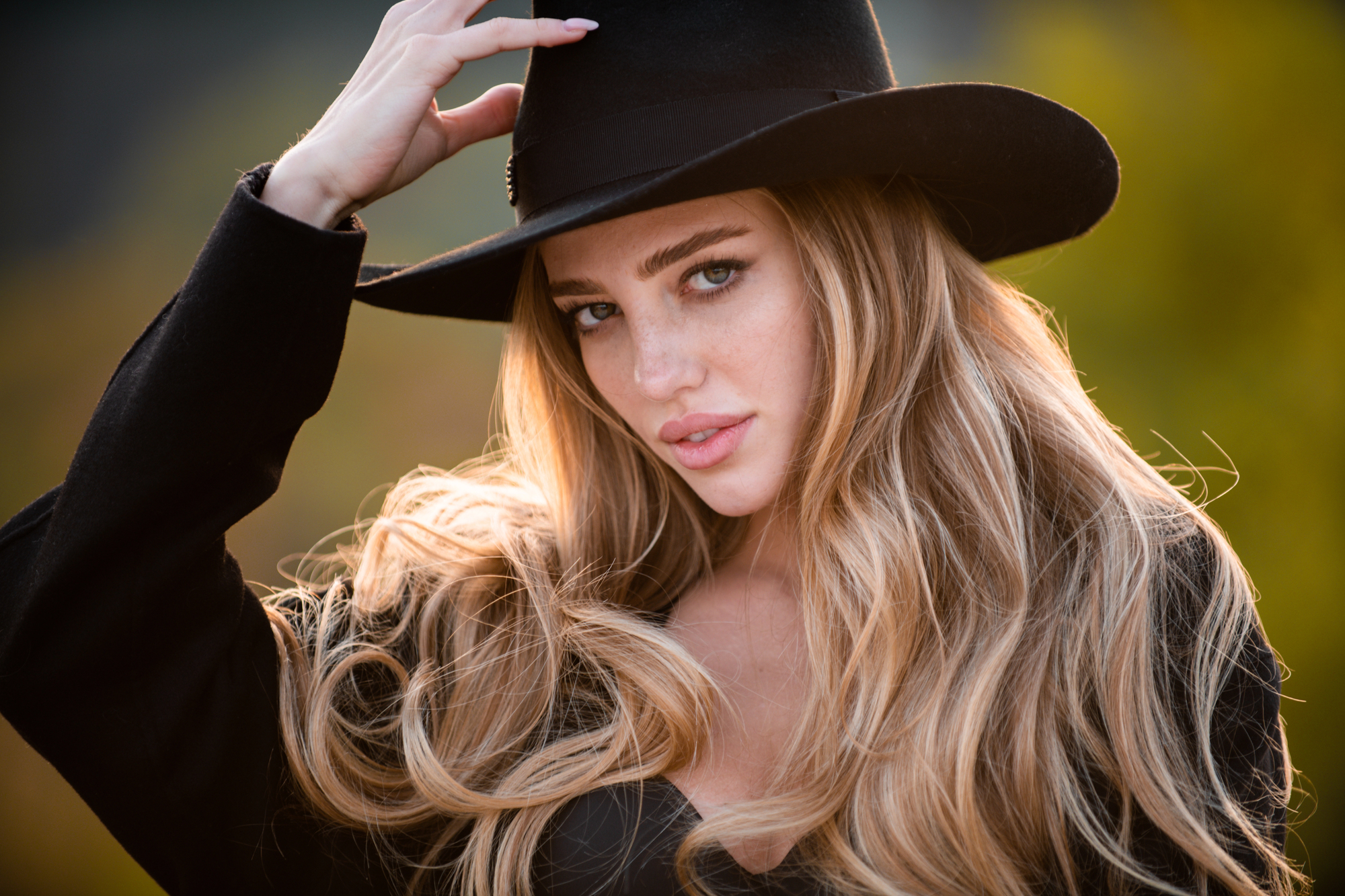 Schöne junge Blondine mit schwarzem Hut.