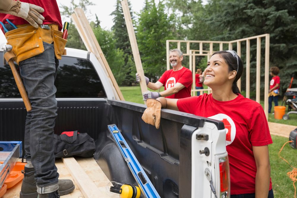 Freiwillige laden Holz von einem Transporter.